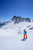 Woman backcountry skiing ascending towards Cima Vedretta Nera, Cima Cornisello in background, Cima Vedretta Nera, Adamello group, Trentino, Italy