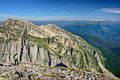 Woman hiking ascending towards Corno Grande, Gran Sasso-group in background, Corno Grande, Gran Sasso, Abruzzi, Italy