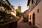 Aufgang zum ersten Burghof mit Blick zum Bergfried der Wartburg im Licht der untergehenden Sonne, Eisenach, Thüringen, Deutschland, Europa