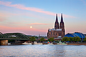 Full moon, view over the Rhine river to Hohenzollern bridge, Cologne cathedral and musical dome, Cologne, North Rhine-Westphalia, Germany