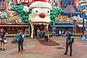 Park guests pose for pictures in front of the Krustyland attraction at Universal Studios theme park in Orlando, Florida.,X2I-2166877 - © - Ron Buskirk