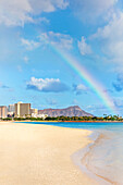 'View of Waikiki beach and Diamond Head crater at Ala Moana Beach Park with a rainbow overhead; Honolulu, Oahu, Hawaii, United States of America'