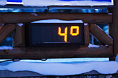 An outdoor digital thermometer in the snow in winter measuring four degrees fahrenheit, Alaska, United States of America