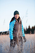 Porträt einer jungen Frau, die einen Strickmütze trägt und auf einem Feld steht, Homer, Alaska, Vereinigte Staaten von Amerika