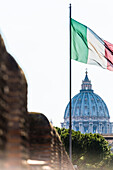 The St. Peter's Basilica Basilica di San Pietro with the blowing national flag, Rome, Latium, Italy