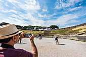 Ein Tourist schießt Fotos in der Arena der antiken Stadt, Pompeji, Golf von Neapel, Kampanien, Italien