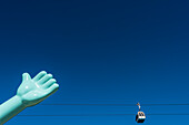 Die Gondelbahn Teleférico do Parque das Nações im Parque das Nações hinter einer großen Hand einer Statue, Lissabon, Portugal