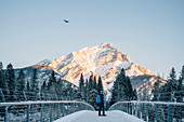 Man standing on a bridge, Banff, Banff National Park, Alberta, winter, snow, mountains, Canada, North America