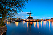 Abenddämmerung Lichter auf der Windmühle De Adriaan reflektiert in den Fluss Spaarne, Haarlem, Nord-Holland, Niederlande, Europa