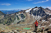 Frau beim Wandern blickt auf Bergseen, Feuersteine im Hintergrund, Wilder Freiger, Stubaier Alpen, Tirol, Österreich