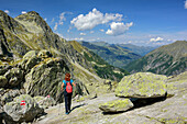 Woman hiking descending from Korntauern towards Boeckstein, Korntauern, Tauern ridgeway, High Tauern range, Salzburg, Austria