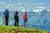 Three persons looking towards Grossvenediger, Pinzgau walk, Kitzbuehel Alps, Salzburg, Austria