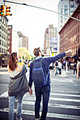 Couple crossing city street, rear view