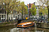 Canal boat passing under a bridge on Brouwersgracht, Amsterdam, Netherlands, Europe