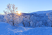 Die Sonne geht von den Gipfeln an der Grenze zwischen Schweden und Norwegen, Riskgransen, Norbottens Ian, Lappland, Schweden, Skandinavien, Europa