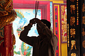 Buddhist worshipper burning incense sticks, Chua On Lang Taoist Temple, Ho Chi Minh City, Vietnam, Indochina, Southeast Asia, Asia