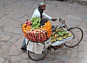 Bhaktapur, Nepal, A fruits vendor, walk with his bike in the old street of Durbar sqare