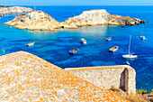 Cretaccio Island seen from Santa Maria Abbey, the highest point of San Nicola Island with boats moored in the bay, Tremiti Islands, Apulia, Italy