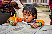 Child plays with colored pens,Rasuwa district, Bagmati region,Nepal,Asia