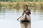 Junger Mbunza-Mann, der auf Okavango-Fluss, lebendes Museum Mbunza, Kavango-Region, Namibia