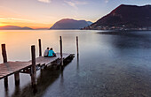 Ein Paar auf dem Pier von Sulzano, vor Monte Isola, Provinz Brescia, Iseo See, Lombardei, Italien