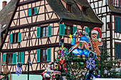 Christmas ornaments frame the typical houses of the medieval old town Colmar Haut-Rhin department Alsace France Europe