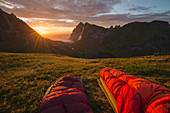 Den farbenprächtigen Sommersonnenuntergang über dem Strand von Bunes beobachten Sie von Schlafsäcken, Moskenesøy, Lofoten, Norwegen