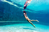 Young woman diving in swimming pool