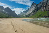 Zwei Wanderer hinterlassen Footprints im Sand am Strand von Horseid, Moskenesøy, Lofoten, Norwegen