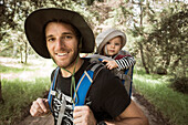 Mann und sein Baby in Träger am Wanderweg in Rancho Santa Elena, Hidalgo, Mexiko