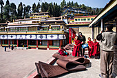 Visitors taking photos with Rumtek monks. Rumtek Monastery, also called the Dharmachakra Centre, founded by Wangchuk Dorje, 9th Karmapa Lama is a gompa located in the Indian state of Sikkim near the capital Gangtok. India.