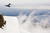 Ein weiblicher Snowboarder trifft einen Sprung bei Cerro Catedral in Argentinien