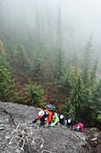A group of people enjoy a Via Ferrata on a rainy fall day Squamish, British Columbia.