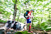 Mann mit seinem Hund, der im Wald des weißen Berges wandert