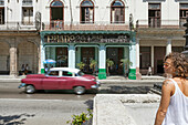 Tourist Mädchen in den Straßen von La Habana mit einem alten Auto im Hintergrund bewegen