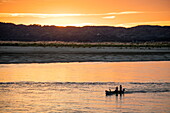 Fishing boat on Ayeyarwady (Irrawaddy) river at sunset, near Mingun, Sagaing, Myanmar
