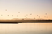 Hot air balloons above the ancient temples of Bagan seen from Ayeyarwady (Irrawaddy) river cruise ship Anawrahta (Heritage Line) at sunrise, Bagan, Mandalay, Myanmar