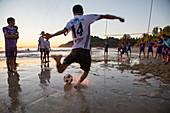 Soccer player shoots winning penalty kick during official league match on Ngapali beach, Ngapali, Thandwe, Myanmar