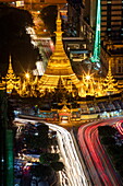 Langzeitbelichtung mit Lichtstreifen von Autos auf der Sule Pagoda Road und die beleuchtete Sule-Pagode bei Nacht vom Sakura Tower aus gesehen, Yangon, Yangon, Myanmar