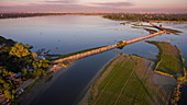 Aerial of tourists on U Bein Bridge and rowboats on Taungthaman Lake at sunset, Amarapura, Mandalay, Myanmar