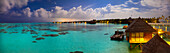 Panoramablick von Überwasserlandhäusern unter dem Mondschein bei Gili Lankanfushi, auf den Malediven.