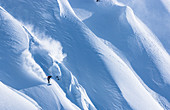 Professional snowboarder Robin Van Gyn, rides fresh powder on a sunny day while snowboarding in Haines, Alaska.