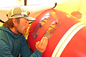 A mountain ranger and paramedic talking to a patient with altitude cerebral edema lying in a portable height chamber in the medical camp on Denali