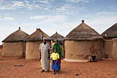 Ein junges Schulmädchen mit ihren Eltern vor ihrem Haus in Tinguri, Nord-Ghana, Westafrika, Afrika