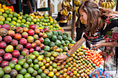 Ein VSO-Freiwilliger kauft frisches Obst aus einem Obststand am Straßenrand in Addis Abeba, Äthiopien, Afrika