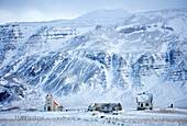 Church and isolated farm against snow covered mountains, winter afternoon on the road to the Snaefellsnes Peninsula, Iceland, Polar Regions