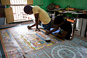 Pattachitra artists painting large traditional Odishan scroll Thia Badhia painting on cloth of the temple of Hindu god Jagannath, Odisha, India, Asia