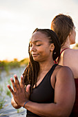 Photograph of woman mediating with hands clasped (Anjali mudra), Newport, Rhode Island, USA