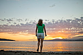 Fotografie der hinteren Ansicht der Frau stehend an Kitsilano-Strand während des Sonnenuntergangs, Vancouver, Britisch-Columbia, Kanada