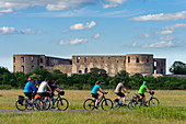Bicycle tourists in front of castle, Borgholm Slott Oeland, Schweden